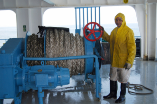 Arbeiter an Deck mit Schleppwinde